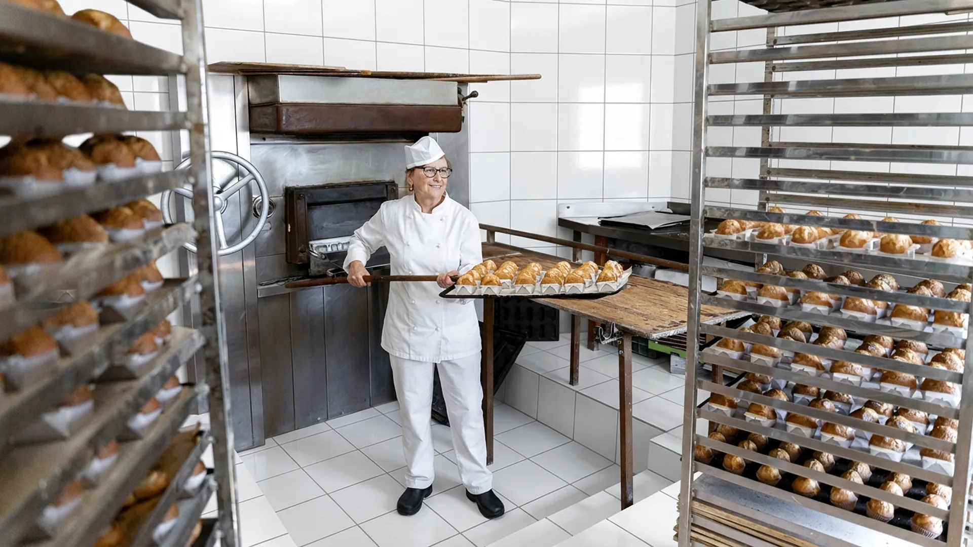 Panadera retirando facturas del horno con harina Sarita